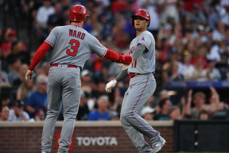 Jun 24, 2023; Denver, Colorado, USA; Los Angeles Angels left fielder Taylor Ward (3) and Los Angeles Angels designated hitter Shohei Ohtani (17) slaps hands after they both scored in the third inning against the Colorado Rockies at Coors Field. Mandatory Credit: John Leyba-USA TODAY Sports