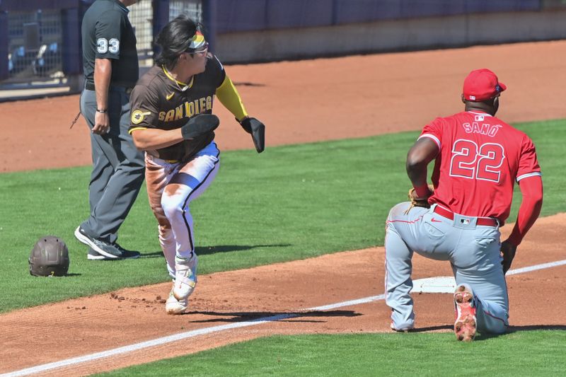 Mar 1, 2024; Peoria, Arizona, USA; San Diego Padres shortstop Ha-Seong Kim (7) runs home as Los Angeles Angels third baseman Miguel Sano (22) looks on in the second inning during a spring training game at Peoria Sports Complex. Mandatory Credit: Matt Kartozian-USA TODAY Sports