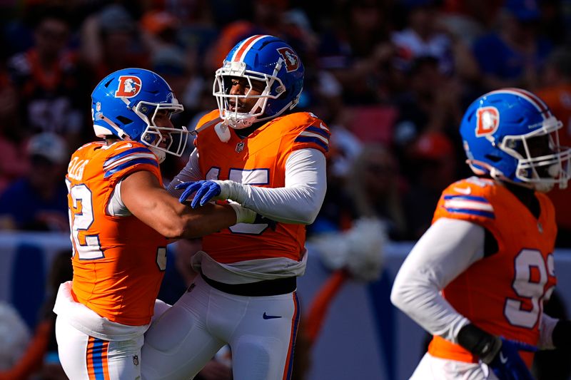 Denver Broncos linebacker Nik Bonitto (15) celebrates his sack of Las Vegas Raiders quarterback Gardner Minshew (15) with teammate linebacker Jonah Elliss (52) during the second half of an NFL football game, Sunday, Oct. 6, 2024, in Denver. (AP Photo/David Zalubowski)