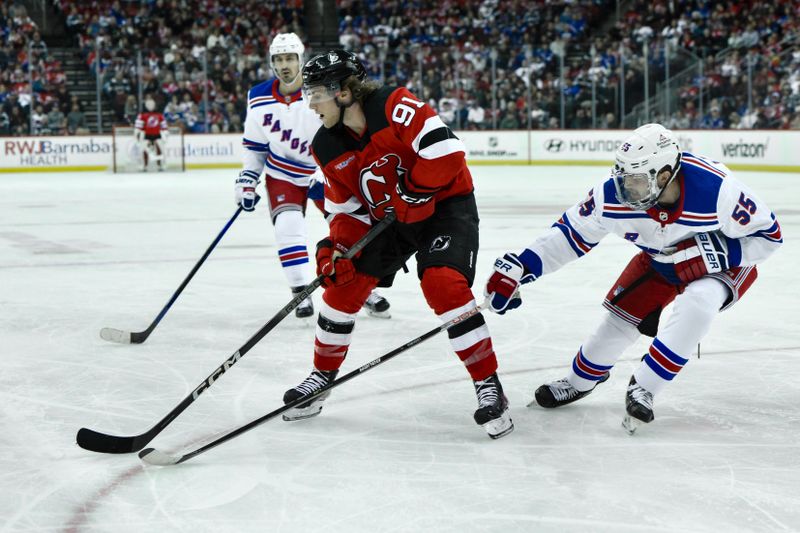 Feb 22, 2024; Newark, New Jersey, USA; New Jersey Devils center Dawson Mercer (91) skates with the puck while being defended by New York Rangers defenseman Ryan Lindgren (55) during the second period at Prudential Center. Mandatory Credit: John Jones-USA TODAY Sports