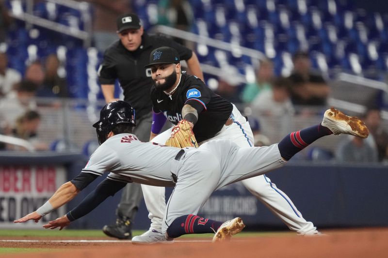 Jun 7, 2024; Miami, Florida, USA;  Miami Marlins third baseman Emmanuel Rivera (15) tags out Cleveland Guardians center fielder Tyler Freeman (2) trying to steal third base in the first inning at loanDepot Park. Mandatory Credit: Jim Rassol-USA TODAY Sports