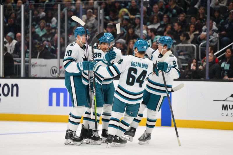 Nov 30, 2024; Seattle, Washington, USA; The San Jose Sharks celebrate after a goal scored by defenseman Mario Ferraro (38) during the first period against the Seattle Kraken at Climate Pledge Arena. Mandatory Credit: Steven Bisig-Imagn Images