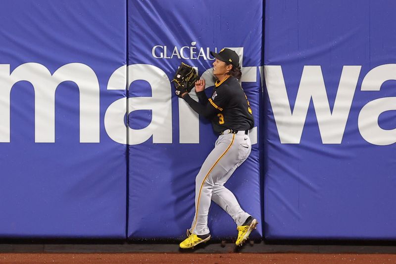 May 14, 2025; New York City, New York, USA; Pittsburgh Pirates center fielder Ji Hwan Bae (3) crashes into the wall after catching the final out of the game on a fly ball by New York Mets second baseman Luisangel Acuna (not pictured) during the ninth inning at Citi Field. Mandatory Credit: Brad Penner-Imagn Images