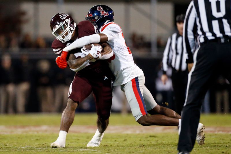 Nov 23, 2023; Starkville, Mississippi, USA; Mississippi State Bulldogs running back Jeffery Pittman (25) runs the ball as Mississippi Rebels linebacker Khari Coleman (23) makes the tackle during the first half at Davis Wade Stadium at Scott Field. Mandatory Credit: Petre Thomas-USA TODAY Sports