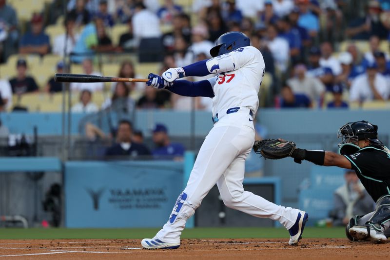 Jul 2, 2024; Los Angeles, California, USA;  Los Angeles Dodgers left fielder Teoscar Hernandez (37) hits an RBI single during the first inning against the Arizona Diamondbacks at Dodger Stadium. Mandatory Credit: Kiyoshi Mio-USA TODAY Sports