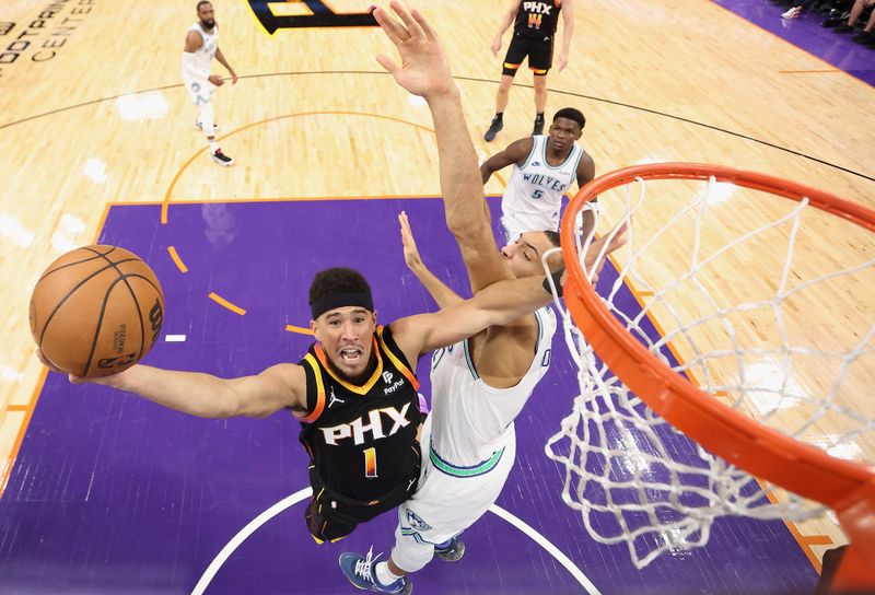 PHOENIX, ARIZONA - NOVEMBER 15: Devin Booker #1 of the Phoenix Suns lays up a shot against Rudy Gobert #27 of the Minnesota Timberwolves during the firstr half of the NBA game at Footprint Center on November 15, 2023 in Phoenix, Arizona. The Suns defeated the Timberwolves 133-115. NOTE TO USER: User expressly acknowledges and agrees that, by downloading and or using this photograph, User is consenting to the terms and conditions of the Getty Images License Agreement.  (Photo by Christian Petersen/Getty Images)