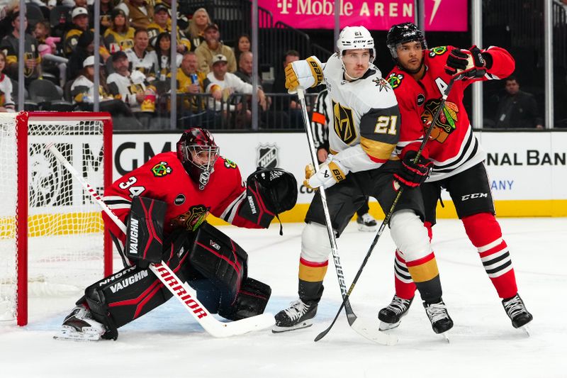 Oct 27, 2023; Las Vegas, Nevada, USA; Chicago Blackhawks goaltender Petr Mrazek (34) defends his net as Vegas Golden Knights center Brett Howden (21) battles against Chicago Blackhawks defenseman Seth Jones (4) during the third period at T-Mobile Arena. Mandatory Credit: Stephen R. Sylvanie-USA TODAY Sports