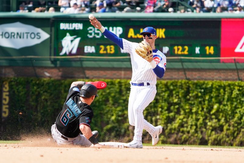 May 6, 2023; Chicago, Illinois, USA; Chicago Cubs second baseman Nico Hoerner (2) forces out Miami Marlins pinch-runner Peyton Burdick (6) at second base during the eighth inning at Wrigley Field. Mandatory Credit: David Banks-USA TODAY Sports