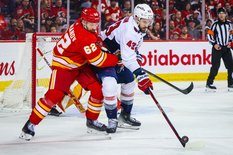 Mar 18, 2024; Calgary, Alberta, CAN; Washington Capitals right wing Tom Wilson (43) and Calgary Flames defenseman Daniil Miromanov (62) battles for the puck during the third period at Scotiabank Saddledome. Mandatory Credit: Sergei Belski-USA TODAY Sports