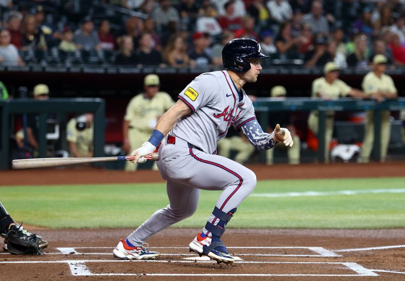 Jul 9, 2024; Phoenix, Arizona, USA; Atlanta Braves outfielder Jarred Kelenic hits a first inning single against the Arizona Diamondbacks at Chase Field. Mandatory Credit: Mark J. Rebilas-USA TODAY Sports