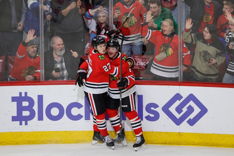 Dec 22, 2023; Chicago, Illinois, USA; Chicago Blackhawks center Ryan Donato (8) celebrates with left wing Lukas Reichel (27) after scoring against the Montreal Canadiens during the first period at United Center. Mandatory Credit: Kamil Krzaczynski-USA TODAY Sports