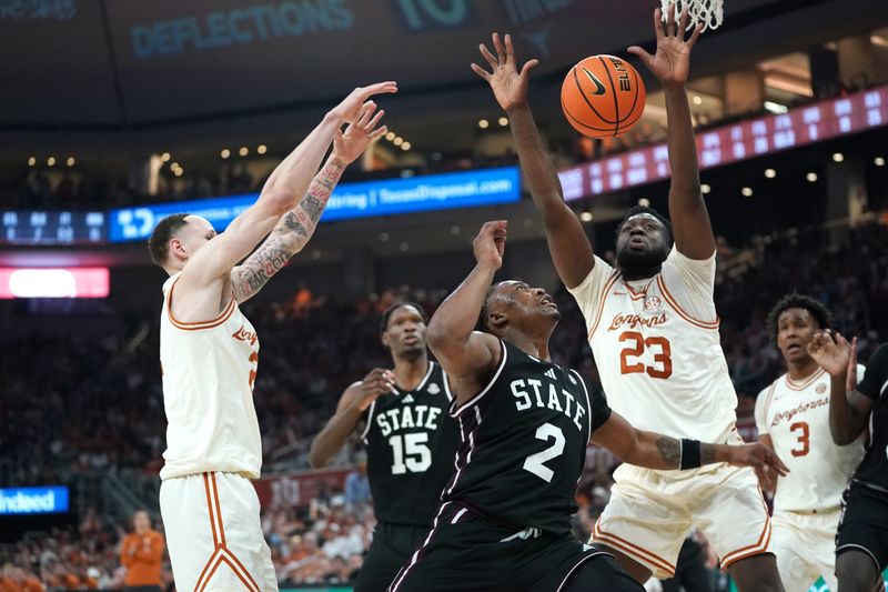 Jan 3, 2026; Austin, Texas, USA; Texas Longhorns forward Lassina Traore (23) rebounds against Mississippi State Bulldogs guard Ja’borri Mcghee (2) during the second half at Moody Center. Mandatory Credit: Dustin Safranek-Imagn Images