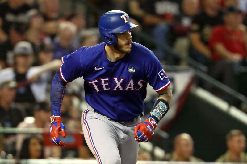 Nov 1, 2023; Phoenix, Arizona, USA; Texas Rangers catcher Jonah Heim (28) hits a two run RBI single against the Arizona Diamondbacks during the ninth inning in game five of the 2023 World Series at Chase Field. Mandatory Credit: Mark J. Rebilas-USA TODAY Sports