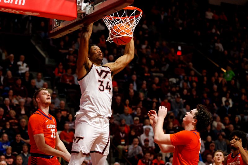 Jan 10, 2024; Blacksburg, Virginia, USA; Virginia Tech Hokies forward Mylyjael Poteat (34) dunks the ball against Clemson Tigers forward Bas Leyte (33) during the second half at Cassell Coliseum. Mandatory Credit: Peter Casey-USA TODAY Sports