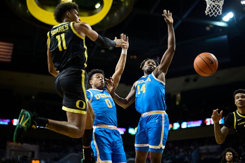 Feb 11, 2023; Eugene, Oregon, USA; Oregon Ducks guard Rivaldo Soares (11) passes the ball during the first half against UCLA Bruins guard Jaylen Clark (0) and forward Kenneth Nwuba (14) at Matthew Knight Arena. Mandatory Credit: Troy Wayrynen-USA TODAY Sports