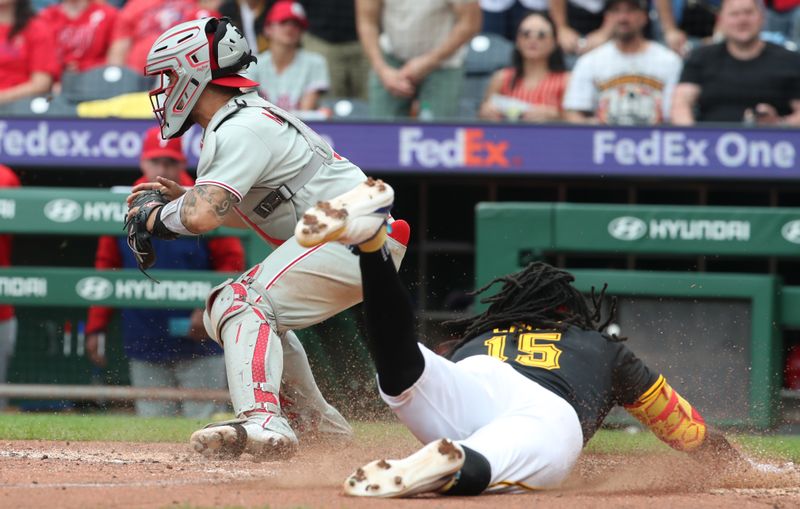 Jun 8, 2025; Pittsburgh, Pennsylvania, USA; Pittsburgh Pirates center fielder Oneil Cruz (15) slides past Philadelphia Phillies catcher Rafael Marchin (13) to score the game winning run in the during the eighth inning at PNC Park. Mandatory Credit: Charles LeClaire-Imagn Images