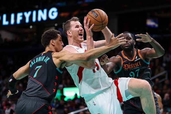 WASHINGTON, DC - DECEMBER 27: Jakob Poeltl #19 of the Toronto Raptors goes to the basket against Patrick Baldwin Jr. #7 and Eugene Omoruyi #97 of the Washington Wizards during the second half at Capital One Arena on December 27, 2023 in Washington, DC. NOTE TO USER: User expressly acknowledges and agrees that, by downloading and or using this photograph, User is consenting to the terms and conditions of the Getty Images License Agreement. (Photo by Scott Taetsch/Getty Images)