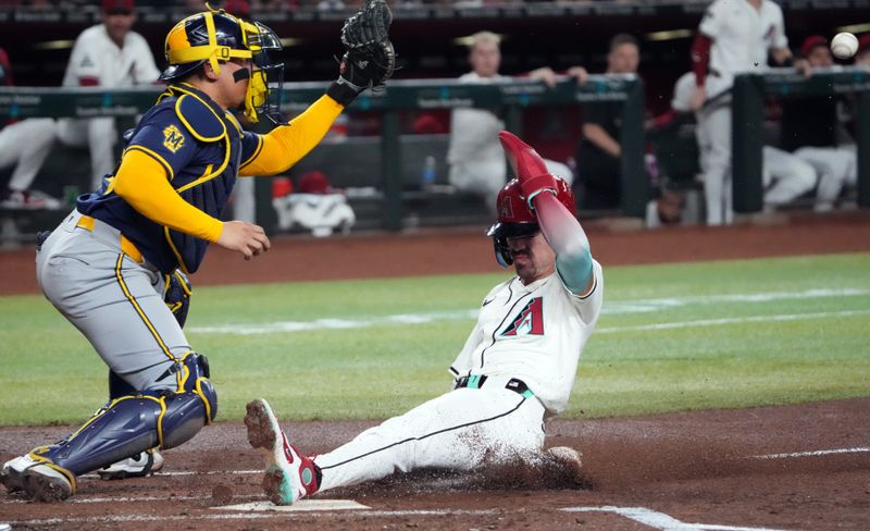 Sep 13, 2024; Phoenix, Arizona, USA; Arizona Diamondbacks outfielder Corbin Carroll (7) slides and beats a throw to Milwaukee Brewers catcher William Contreras (24) during the first inning at Chase Field. Mandatory Credit: Joe Camporeale-Imagn Images