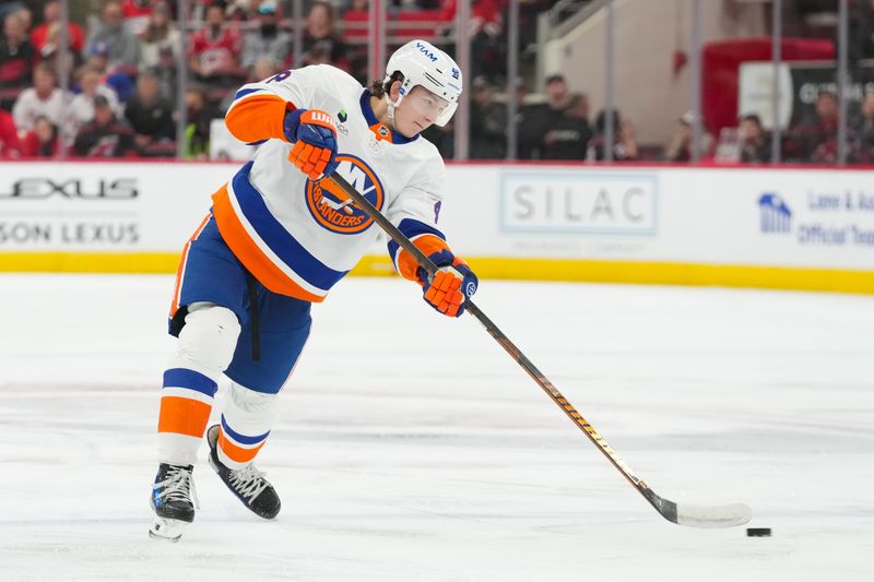 Oct 30, 2025; Raleigh, North Carolina, USA;  New York Islanders defenseman Matthew Schaefer (48) takes a shot against the Carolina Hurricanes during the second period at Lenovo Center. Mandatory Credit: James Guillory-Imagn Images