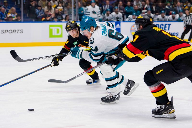 Dec 23, 2023; Vancouver, British Columbia, CAN; San Jose Sharks forward Mikael Granlund (64) drives through Vancouver Canucks forward Elias Pettersson (40) and defenseman Filip Hronek (17) in the second period at Rogers Arena. Mandatory Credit: Bob Frid-USA TODAY Sports