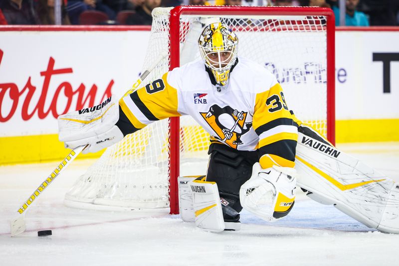 Oct 22, 2024; Calgary, Alberta, CAN; Pittsburgh Penguins goaltender Alex Nedeljkovic (39) controls the puck against the Calgary Flames during the second period at Scotiabank Saddledome. Mandatory Credit: Sergei Belski-Imagn Images