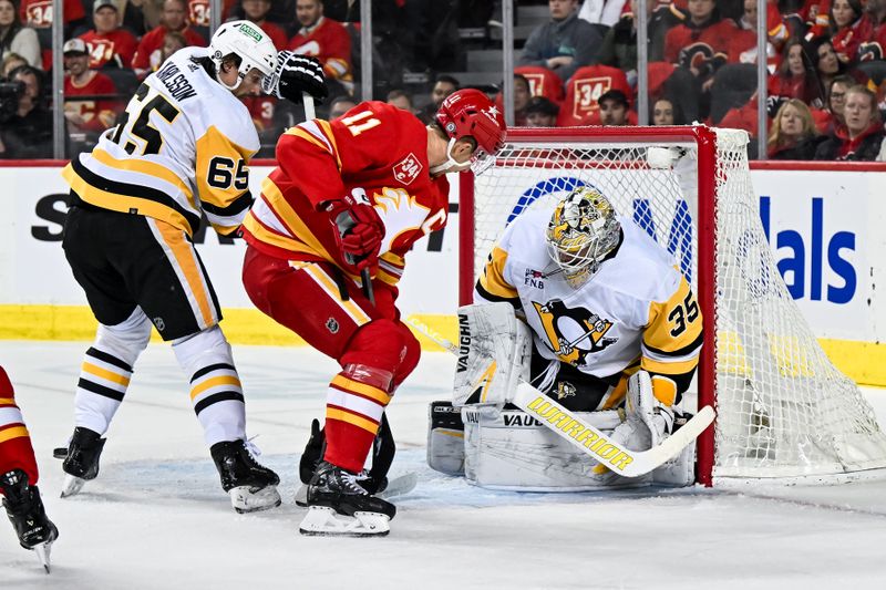 Mar 2, 2024; Calgary, Alberta, CAN; Pittsburgh Penguins goaltender Tristan Jarry (35) makes a save against Calgary Flames center Mikael Backlund (11) during the first period at Scotiabank Saddledome. Mandatory Credit: Brett Holmes-USA TODAY Sports