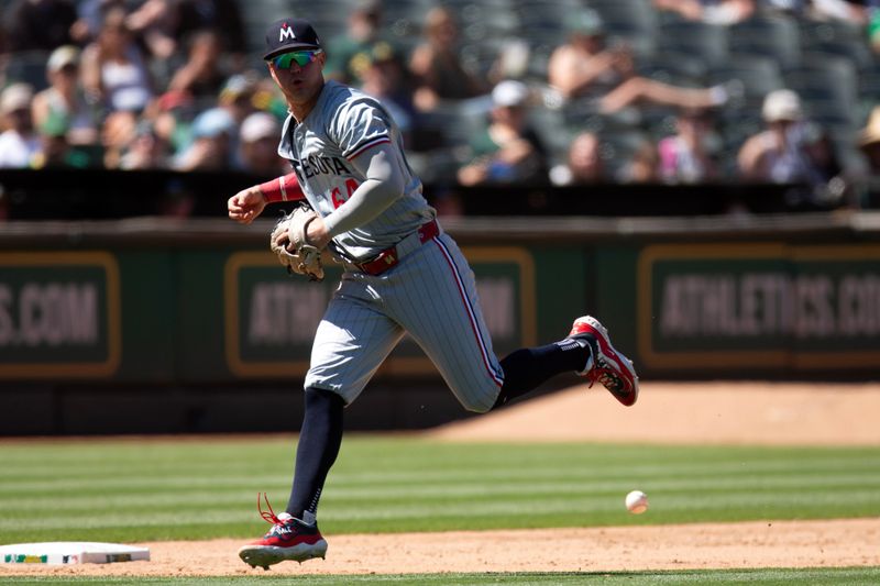 Jun 23, 2024; Oakland, California, USA; Minnesota Twins third baseman Jose Miranda (64) attempts to field a ball during the ninth inning at Oakland-Alameda County Coliseum. Mandatory Credit: D. Ross Cameron-USA TODAY Sports