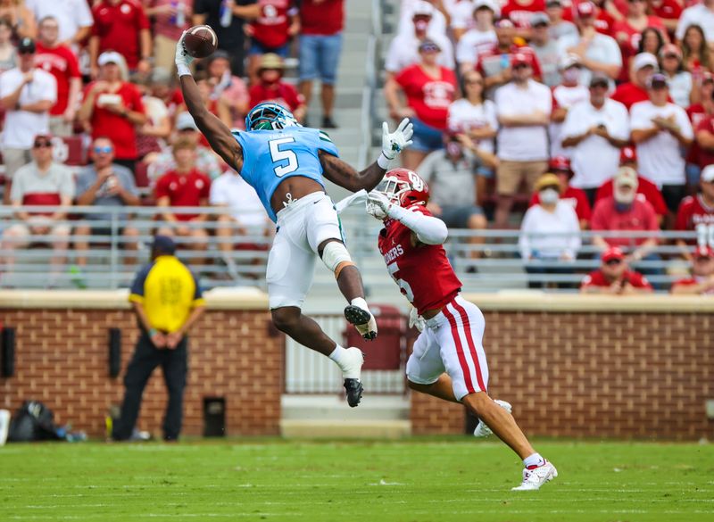 Sep 4, 2021; Norman, Oklahoma, USA;  Tulane Green Wave running back Ygenio Booker (5) makes a one handed leaping catchin fron tof Oklahoma Sooners defensive back Billy Bowman (5) during the first quarter at Gaylord Family-Oklahoma Memorial Stadium. Mandatory Credit: Kevin Jairaj-USA TODAY Sports