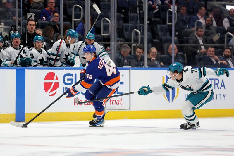 Oct 21, 2025; Elmont, New York, USA; New York Islanders defenseman Matthew Schaefer (48) skates with the puck against San Jose Sharks center Macklin Celebrini (71) during the second period at UBS Arena. Mandatory Credit: Brad Penner-Imagn Images