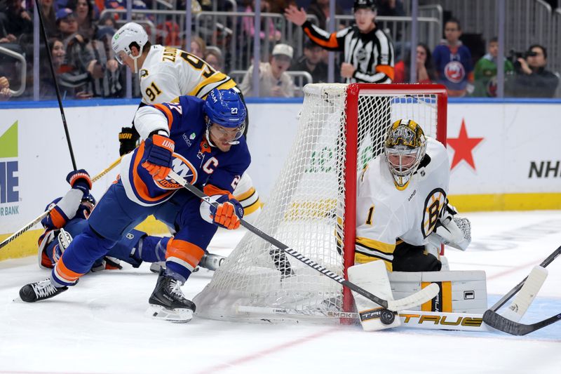 Nov 4, 2025; Elmont, New York, USA; Boston Bruins goaltender Jeremy Swayman (1) makes a save against New York Islanders left wing Anders Lee (27) during the second period at UBS Arena. Mandatory Credit: Brad Penner-Imagn Images