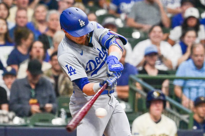 Aug 15, 2024; Milwaukee, Wisconsin, USA; Los Angeles Dodgers third baseman Enrique Hernandez (8) hits a single to drive in a run against the Milwaukee Brewers in the sixth inning at American Family Field. Mandatory Credit: Benny Sieu-USA TODAY Sports