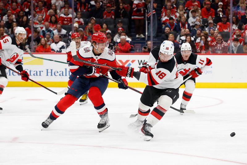 Nov 15, 2025; Washington, District of Columbia, USA; Washington Capitals center Dylan Strome (17) and New Jersey Devils left wing Ondrej Palat (18) battle for the puck during the first period at Capital One Arena. Mandatory Credit: Geoff Burke-Imagn Images
