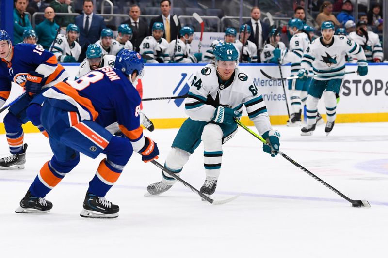 Dec 5, 2023; Elmont, New York, USA; San Jose Sharks right wing Mitchell Russell (64) skates across the blue line defended by New York Islanders defenseman Noah Dobson (8) during the third period at UBS Arena. Mandatory Credit: Dennis Schneidler-USA TODAY Sports