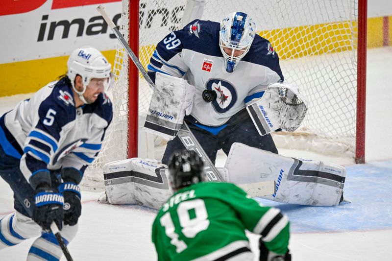 Apr 11, 2024; Dallas, Texas, USA; Winnipeg Jets goaltender Laurent Brossoit (39) stops a shot by Dallas Stars center Sam Steel (18) during the first period at the American Airlines Center. Mandatory Credit: Jerome Miron-USA TODAY Sports