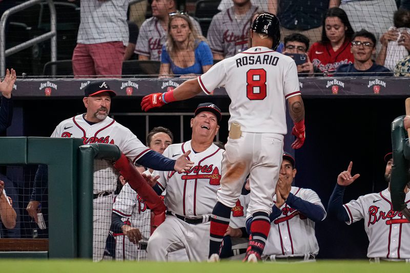 Apr 12, 2023; Cumberland, Georgia, USA; Atlanta Braves left fielder Eddie Rosario (8) reacts with Walt Weiss (left) and Brian Snitker (center) after hitting a home run against the Cincinnati Reds during the eighth inning at Truist Park. Mandatory Credit: Dale Zanine-USA TODAY Sports