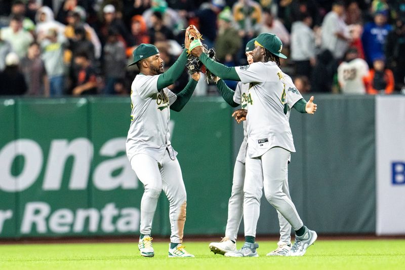 Jul 30, 2024; San Francisco, California, USA;  Oakland Athletics right fielder Lawrence Butler (4) and Oakland Athletics left fielder Miguel Andujar (22) and Oakland Athletics center fielder Daz Cameron (28) celebrate after the game against the San Francisco Giants at Oracle Park. Mandatory Credit: Neville E. Guard-USA TODAY Sports