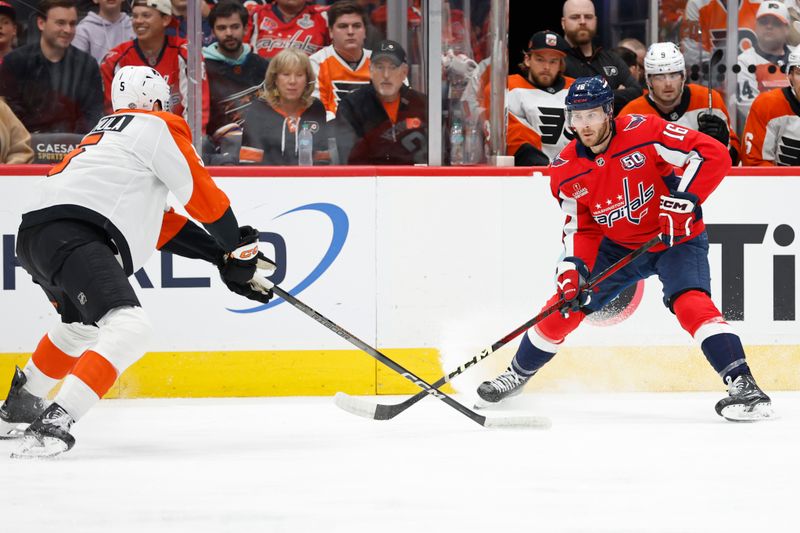 Oct 23, 2024; Washington, District of Columbia, USA; Washington Capitals right wing Taylor Raddysh (16) controls the puck as Philadelphia Flyers defenseman Egor Zamula (5) defends in the first period at Capital One Arena. Mandatory Credit: Geoff Burke-Imagn Images