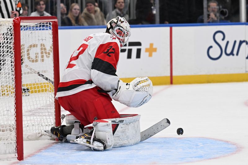 Jan 13, 2026; St. Louis, Missouri, USA; Carolina Hurricanes goaltender Brandon Bussi (32) blocks a shot from the St. Louis Blues in the second period at Enterprise Center. Mandatory Credit: Joe Puetz-Imagn Images