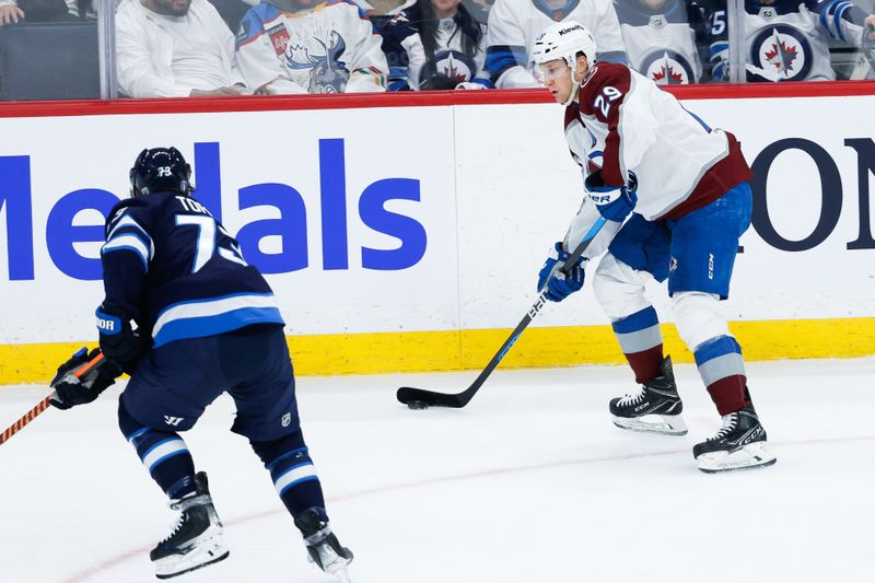 Apr 23, 2024; Winnipeg, Manitoba, CAN; Colorado Avalanche forward Nathan MacKinnon (29) looks to make a pass by Winnipeg Jets forward Tyler Toffoli (73) during the third period in game two of the first round of the 2024 Stanley Cup Playoffs at Canada Life Centre. Mandatory Credit: Terrence Lee-USA TODAY Sports