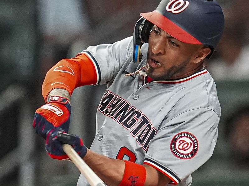 May 29, 2024; Cumberland, Georgia, USA; Washington Nationals outfielder Eddie Rosario (8) singles against the Atlanta Braves during the eighth inning at Truist Park. Mandatory Credit: Dale Zanine-USA TODAY Sports