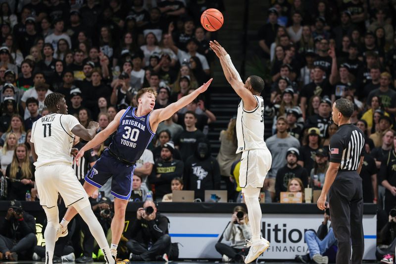 Jan 13, 2024; Orlando, Florida, USA; UCF Knights guard Darius Johnson (3) shoots the ball over Brigham Young Cougars guard Dallin Hall (30) during the first period at Addition Financial Arena. Mandatory Credit: Mike Watters-USA TODAY Sports