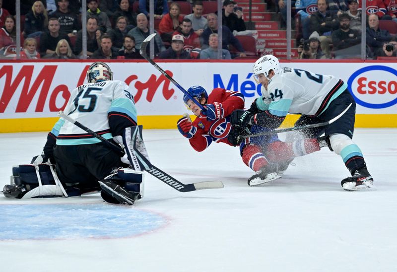 Oct 29, 2024; Montreal, Quebec, CAN; Seattle Kraken goalie Joey Daccord (35) stops Montreal Canadiens forward Emil Heineman (51) with the help of defenseman Jamie Oleksiak (24) during the second period at the Bell Centre. Mandatory Credit: Eric Bolte-Imagn Images