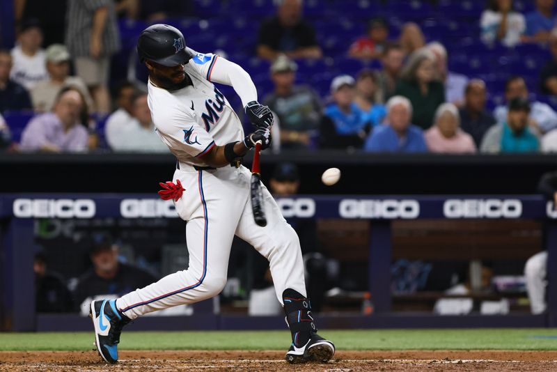 May 1, 2024; Miami, Florida, USA; Miami Marlins designated hitter Bryan De La Cruz (14) hits an RBI double against the Colorado Rockies during the fifth inning at loanDepot Park. Mandatory Credit: Sam Navarro-USA TODAY Sports