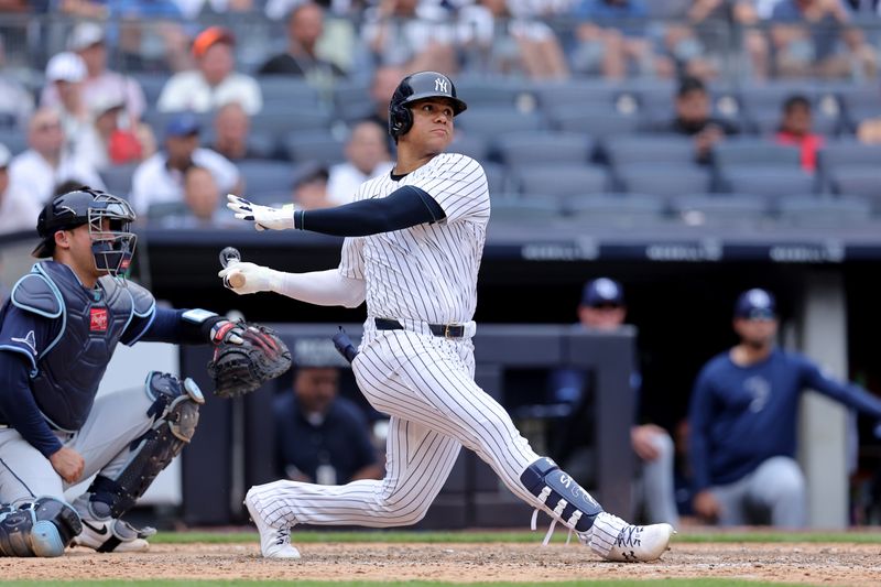 Jul 22, 2024; Bronx, New York, USA; New York Yankees right fielder Juan Soto (22) follows through on a three run home run against the Tampa Bay Rays during the eighth inning at Yankee Stadium. Mandatory Credit: Brad Penner-USA TODAY Sports