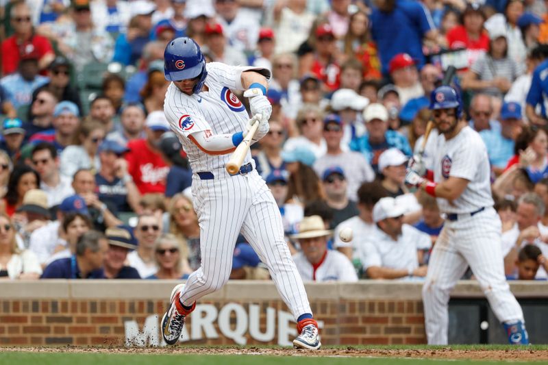 Jul 4, 2024; Chicago, Illinois, USA; Chicago Cubs second baseman Nico Hoerner (2) hits an RBI-single against the Philadelphia Phillies during the fourth inning at Wrigley Field. Mandatory Credit: Kamil Krzaczynski-USA TODAY Sports