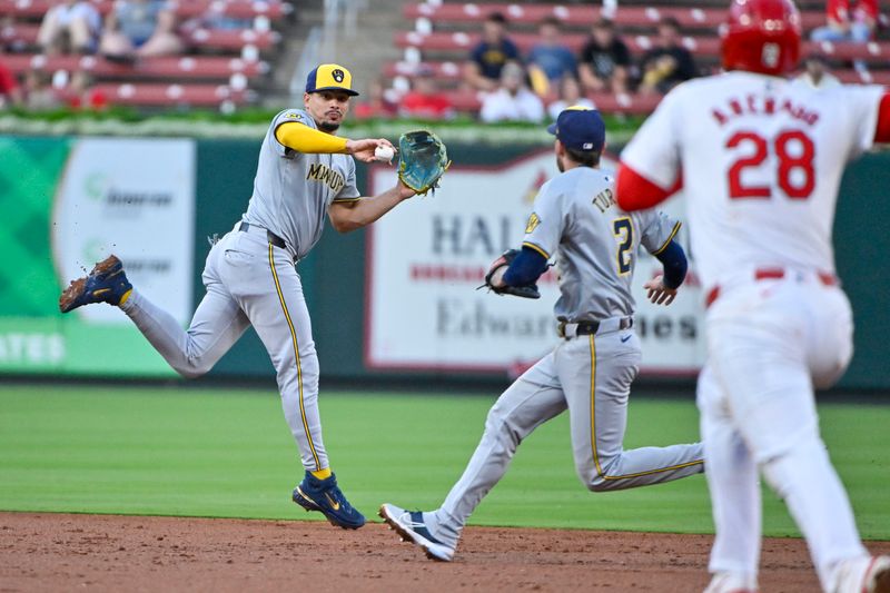 Aug 21, 2024; St. Louis, Missouri, USA;  Milwaukee Brewers shortstop Willy Adames (27) leaps and tosses the ball to second baseman Brice Turang (2) to force out St. Louis Cardinals third baseman Nolan Arenado (not pictured) during the second inning at Busch Stadium. Mandatory Credit: Jeff Curry-USA TODAY Sports