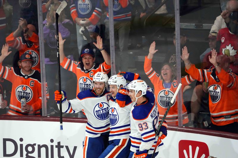 Feb 19, 2024; Tempe, Arizona, USA; Edmonton Oilers left wing Zach Hyman (18) celebrates his goal with Edmonton Oilers center Connor McDavid (97) and Edmonton Oilers center Ryan Nugent-Hopkins (93) against the Arizona Coyotes  during the third period at Mullett Arena. Mandatory Credit: Joe Camporeale-USA TODAY Sports