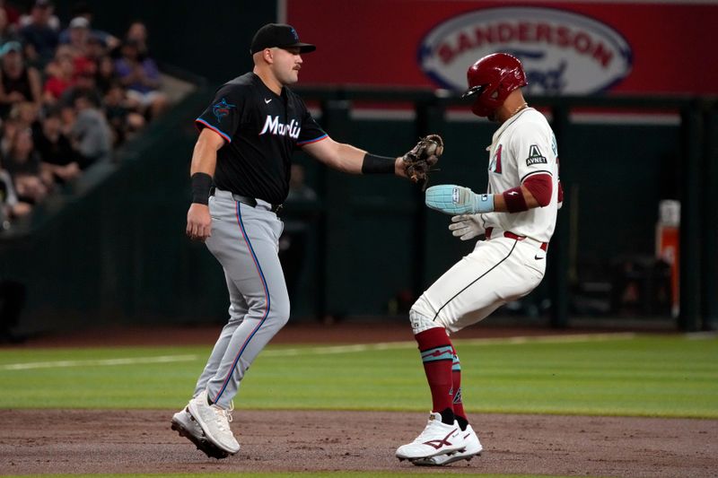 May 24, 2024; Phoenix, Arizona, USA; Miami Marlins third base Jake Burger (36) tags out Arizona Diamondbacks outfielder Lourdes Gurriel Jr. (12) in the first inning at Chase Field. Mandatory Credit: Rick Scuteri-USA TODAY Sports