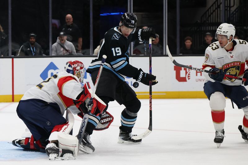 Dec 10, 2025; Salt Lake City, Utah, USA; Utah Mammoth left wing Daniil But (19) plays the puck against Florida Panthers goaltender Sergei Bobrovsky (72) and center Jack Studnicka (53) during the second period at Delta Center. Mandatory Credit: Rob Gray-Imagn Images