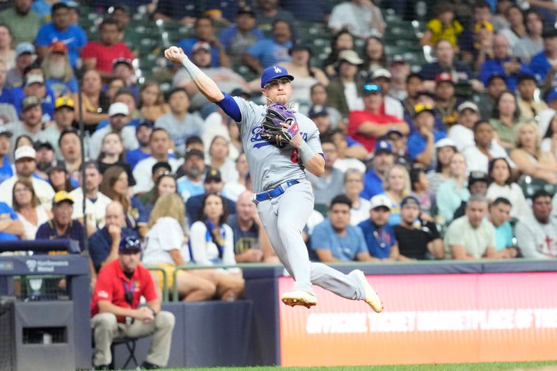 Aug 13, 2024; Milwaukee, Wisconsin, USA;  Los Angeles Dodgers third baseman Enrique Hernandez (8) fields the ball hit by Milwaukee Brewers third baseman Joey Ortiz (3) (not pictured) during the seventh inning at American Family Field. Mandatory Credit: Jeff Hanisch-USA TODAY Sports